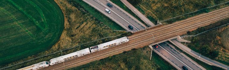 Flygfoto av en väg och järnväg som korsar varandra i två plan.