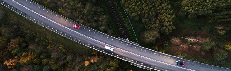 Drönarbild över väg med bilar  i landskap