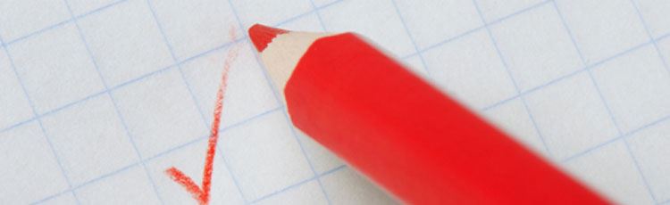 Röd penna som gjort en bock på papper.