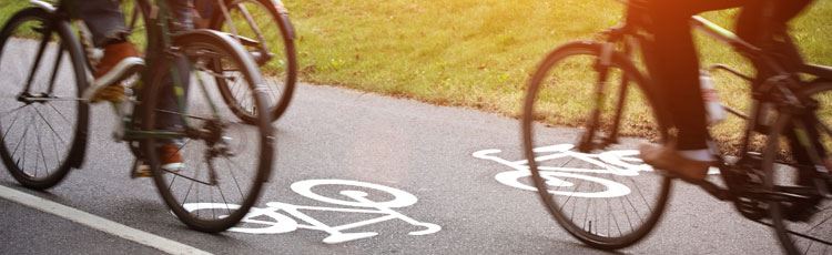 Närbild på tre par cykelhjul som far fram på en cykelbana.