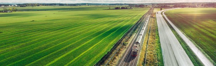 Järnväg och väg i grönt landskap