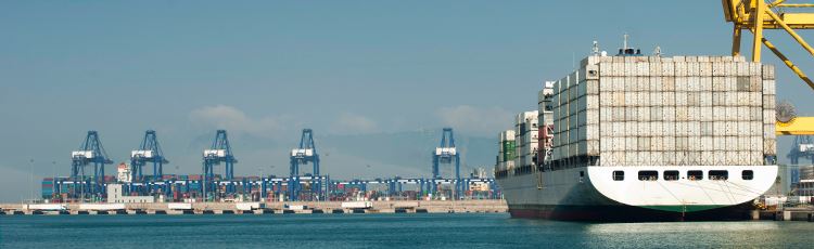Contanierfartyg i hamn, blå himmel och blått vatten