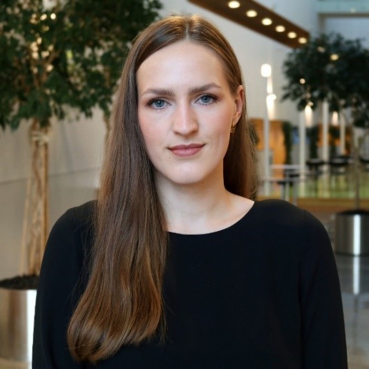 Porträttbild på Caroline Ansins som har långt mörkt hår och svart tröja