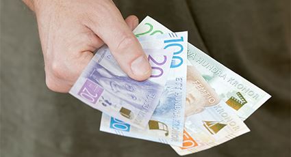 Hand som håller i svenska sedlar.