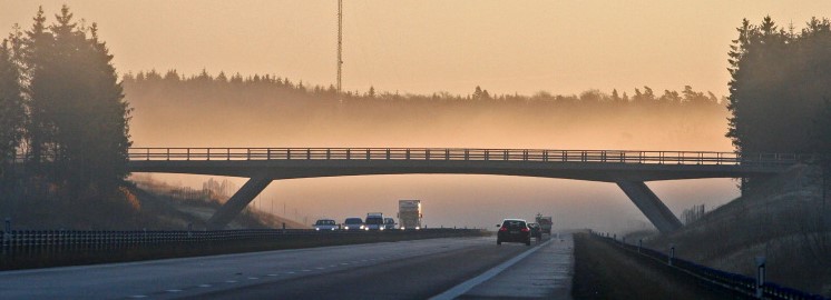 Bridge over road during sunrise.
