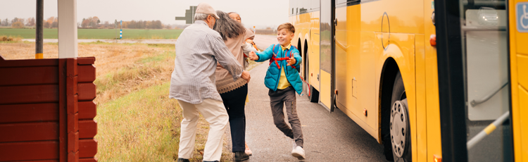 Kärt återseende - ett äldre par som glatt välkomnar barn som kliver av en landsvägsbuss.